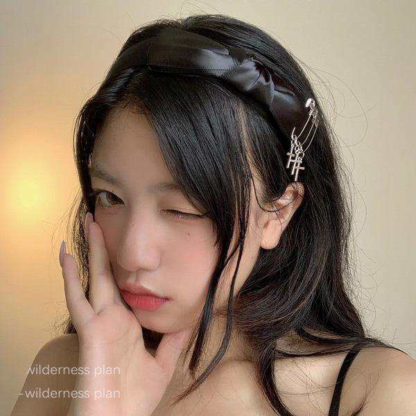 光沢感のあるシルエットが可愛いブラックリボンのカチューシャ。安全ピンとクロスのモチーフがあしらわれたゴシックガール感溢れるアイテムです♪どんなコーデにも合わせやすいカラーリングに他にはない個性的なデザ